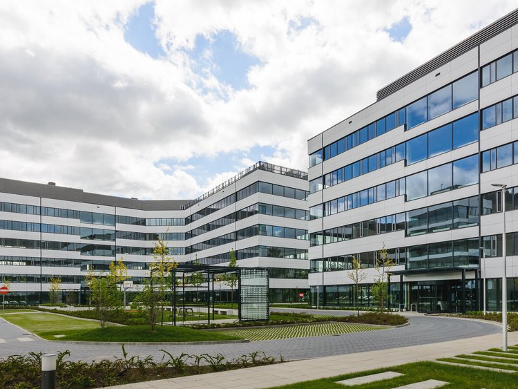 Zdjęcie: Business Garden Poznań: przestronny dziedziniec obsadzony zielenią w otoczeniu nowoczesnych budynków z przeszklonymi elewacjami.